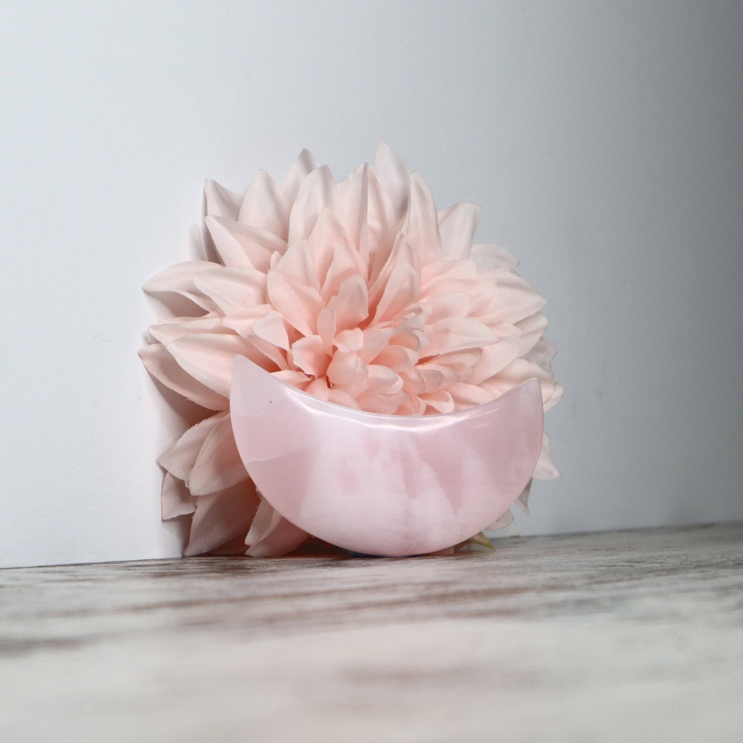 Polished Mangano Calcite moon carving with soft pink tones.