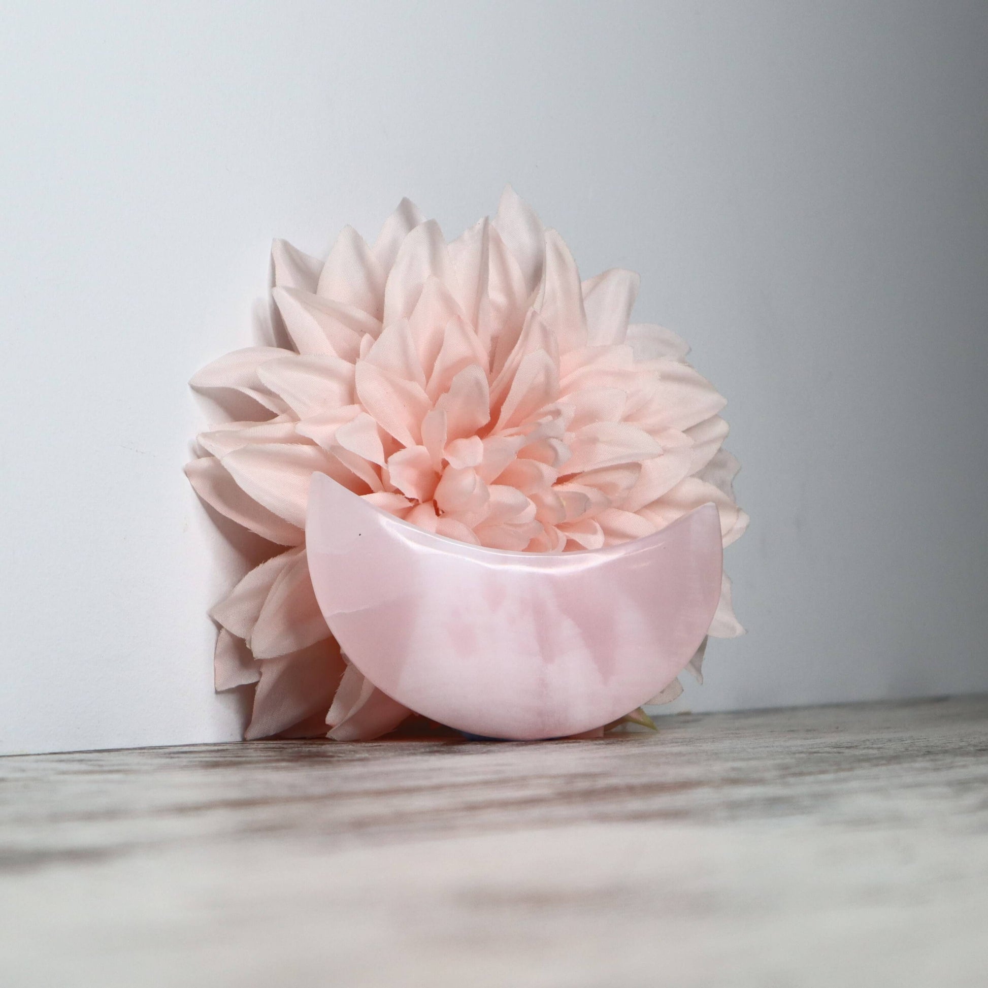 Polished Mangano Calcite moon carving with soft pink tones.